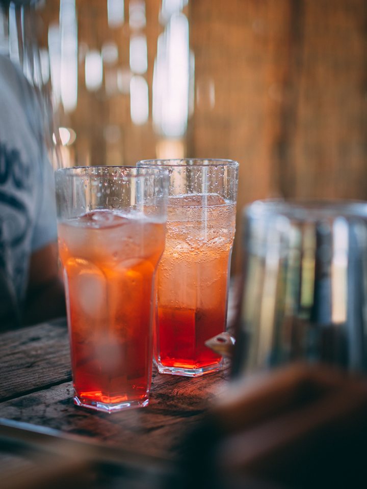 Dos bebidas frías con hielo sobre una mesa de madera