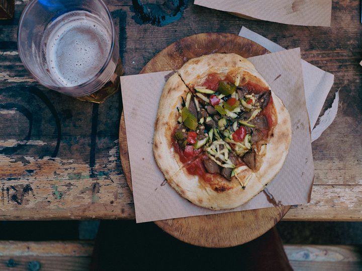Pizza rústica y cerveza sobre una mesa de madera